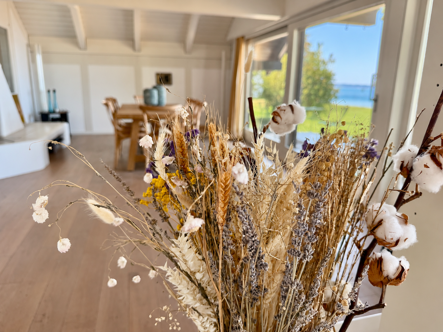 Trockenblumen vor Essbereich mit Seeblick