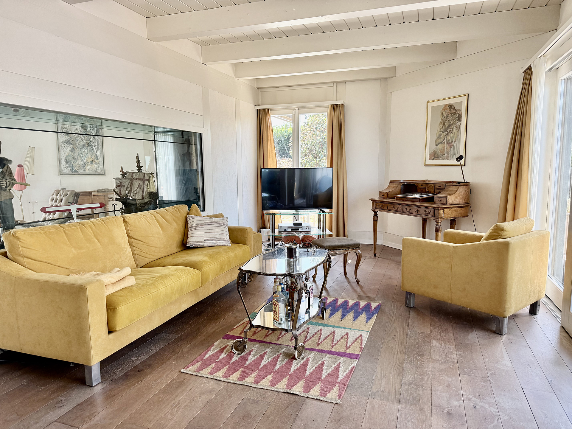 Salon mit gelbem Sofa und Schreibtisch